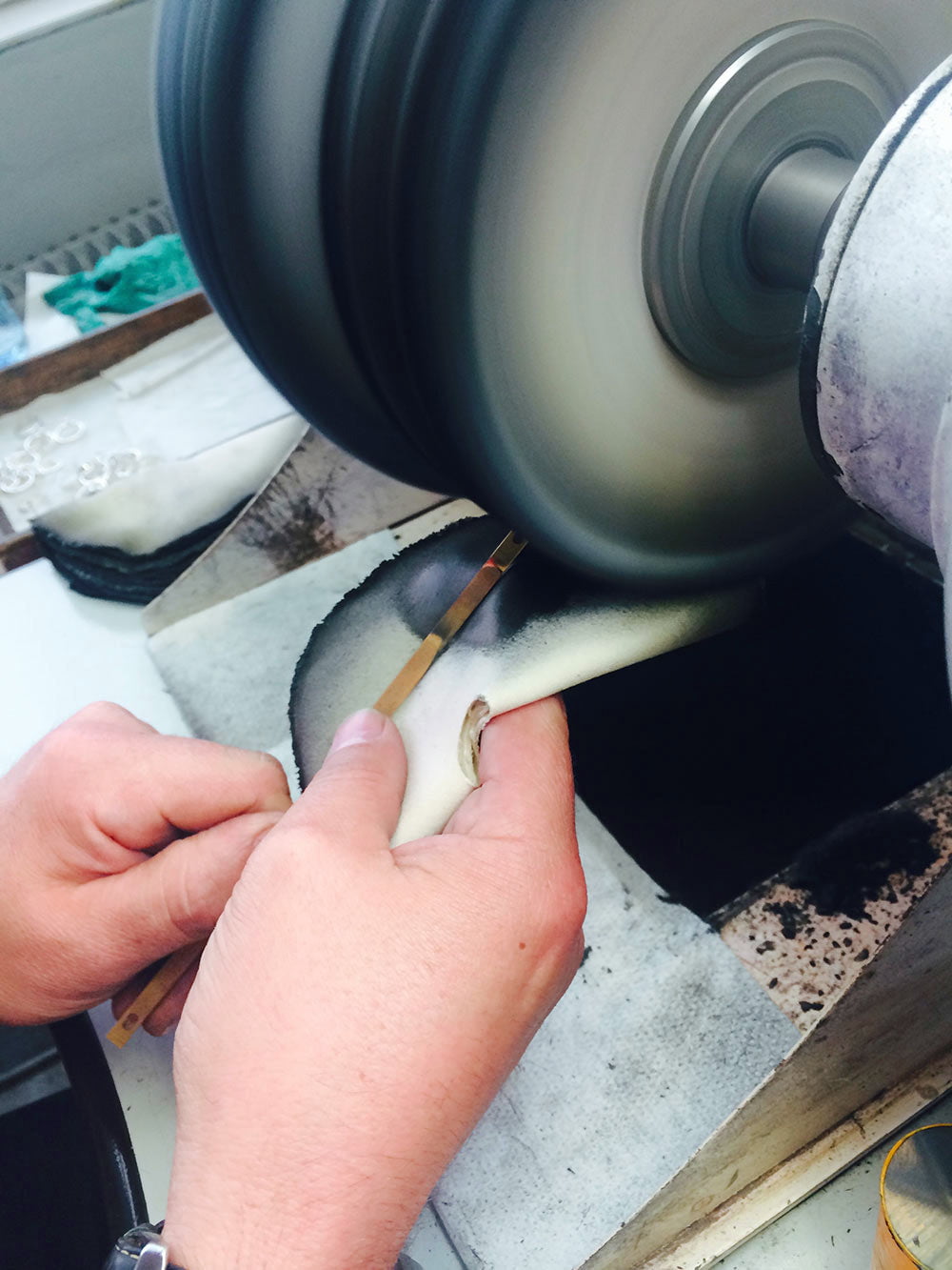 Artisan polissant une barre de métal de bijou
