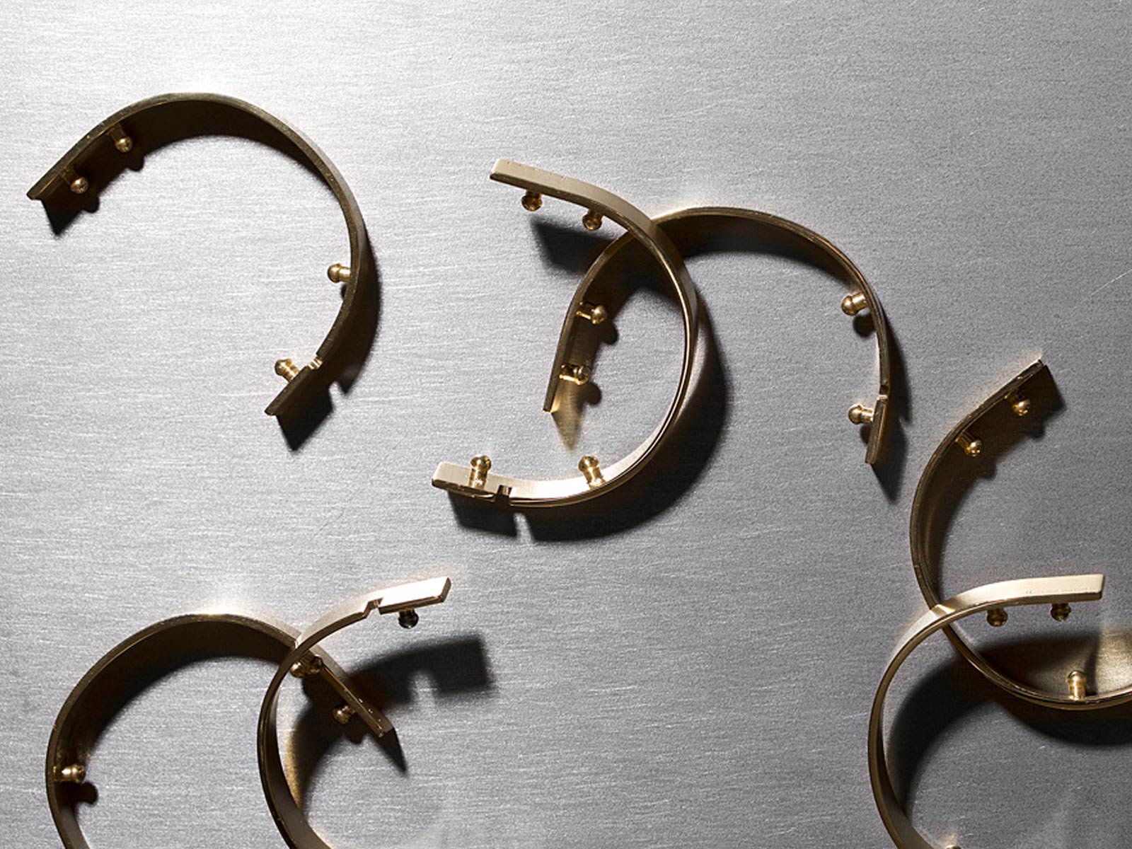 Fermoirs de bracelets U'Turn Ursul à profil ovoïde, design architectural en métal doré.
